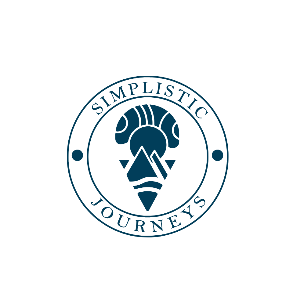 The Simplistic Journeys logo features a circular design with bold, elegant typography and a central emblem representing cultural exploration and adventure. The emblem incorporates a stylized travel-inspired icon, with a mountain and waves, symbolizing diverse travel experiences. The deep blue color palette conveys sophistication, luxury, and a refined global travel experience.